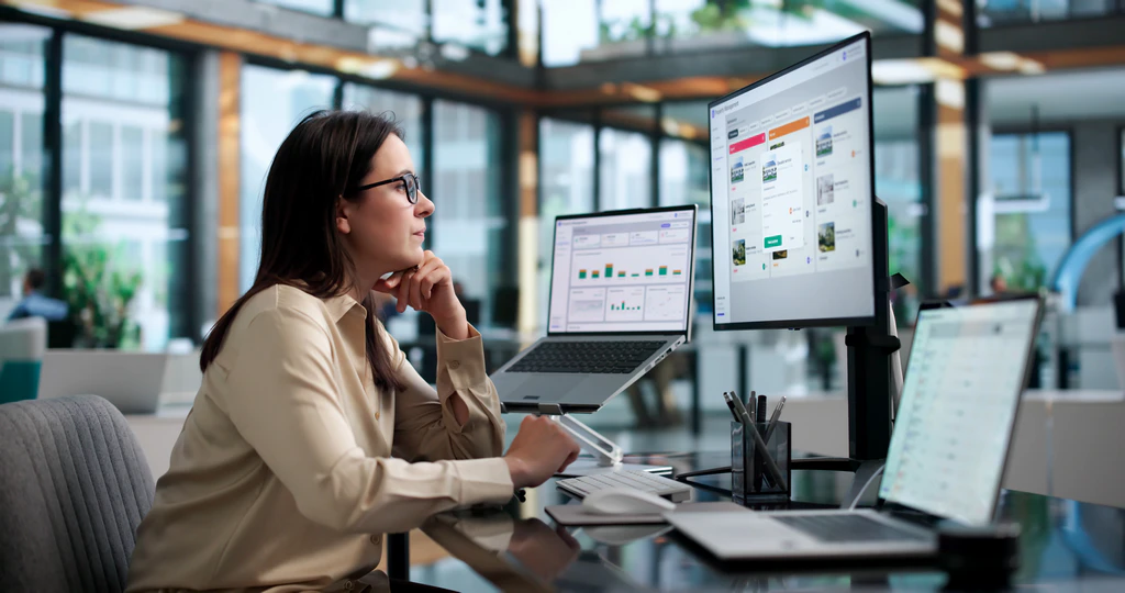Person reviewing information across two computer screens